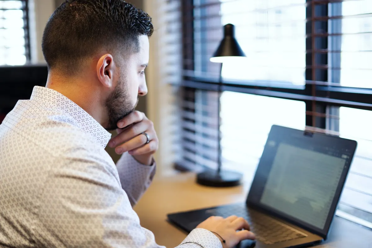 Tyler Costa reviewing a home purchase plan on a laptop