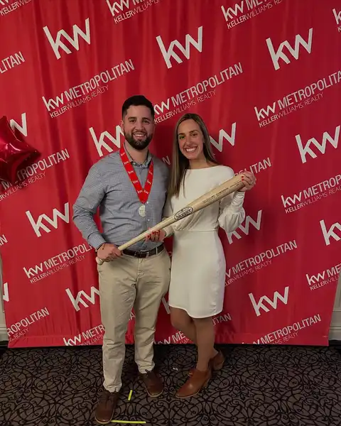 Tyler Costa celebrating with a colleague at a Keller Williams event